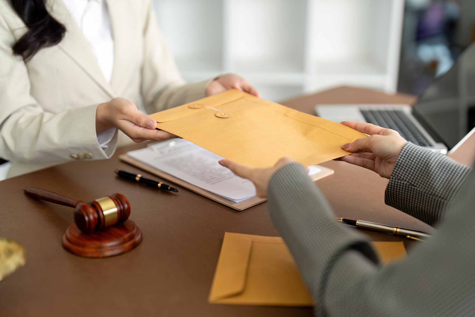 Businessman hands money envelope to lawyer in bribe over illegal business contract documents Investing, accepting bribes, corruption, fraud Businessman hands money envelope to lawyer in bribe over illegal business contract documents Investing, accepting bribes, corruption, fraud.